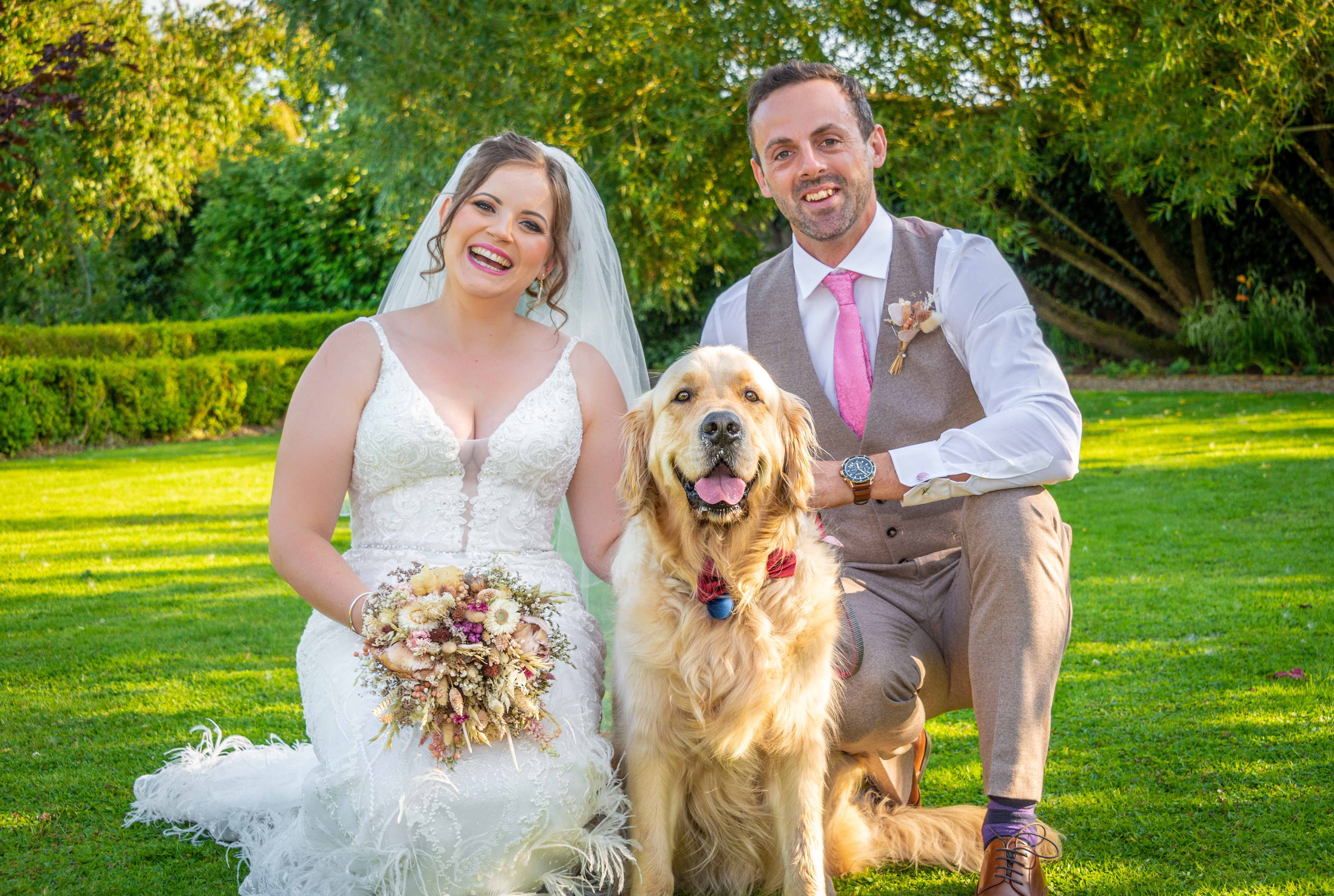A relaxed wedding photo of the couple and their dog at the Secret Garden wedding venue in Kent